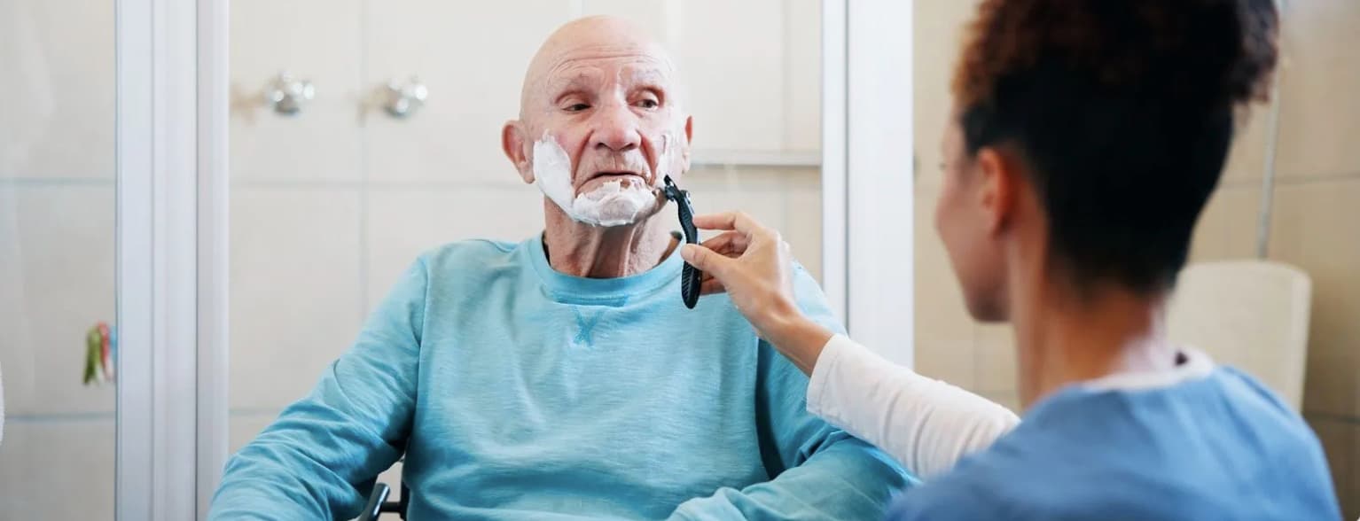 An aide helping a client shave