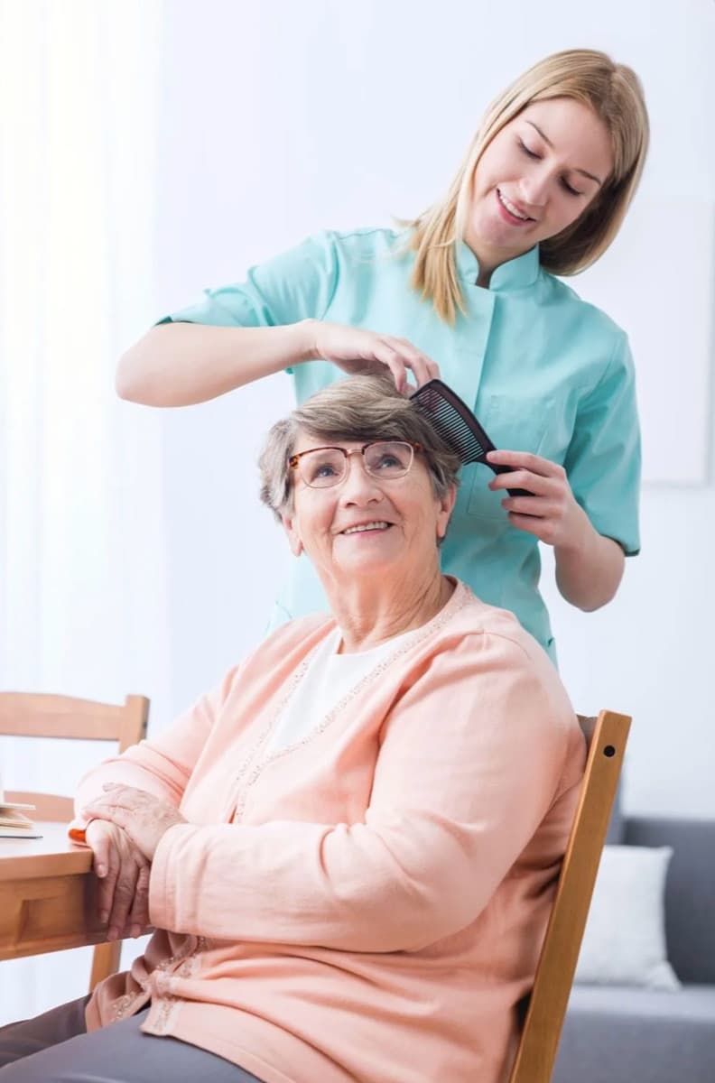 A caregiver combing a client’s hair